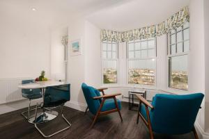 a room with chairs and a table and windows at Harbour Vista in St Ives