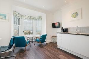 a kitchen with blue chairs and a table and a sink at Harbour Vista in St Ives