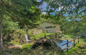 une cascade en face d'un bâtiment avec une maison dans l'établissement Villa con bosco giardino e ruscello ad uso esclusivo, à Borzonasca