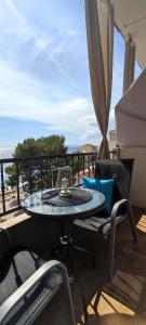 een tafel met stoelen en een parasol op een balkon bij Apartmani Niko Drašnice in Drašnice