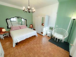 - une chambre avec un lit blanc et une chaise dans l'établissement Villa con bosco giardino e ruscello ad uso esclusivo, à Borzonasca