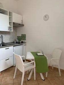 a kitchen with a table with chairs and a green table at A Sorrento in Sorrento
