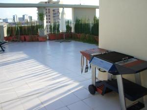 un patio con barbacoa en un edificio en MAGNIFICO ATICO-DUPLEX FRENTE AL MAR, en El Puig