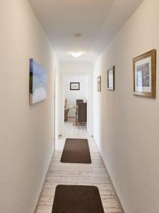 a hallway with two rugs on the walls of a room at Küstenperle - 3 in Cuxhaven