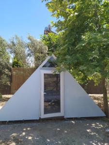 mały biały namiot z drzwiami na dziedzińcu w obiekcie Chillsteps Hostel w mieście Fethiye
