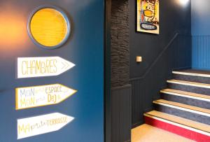 a hallway with stairs and signs on the wall at Mon P'tit Hôtel in Le Grau-dʼAgde