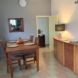 een keuken met een tafel en stoelen en een televisie bij COSY APPARTEMENT MEUBLE & BIEN EQUIPE in Cotonou