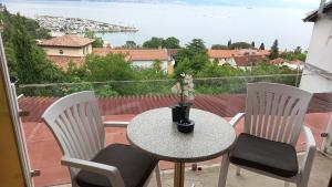 a table and chairs on a balcony with a view at Rooms BELA in Ičići