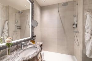 a bathroom with a shower, sink, and toilet at NH Collection Carlo IV in Prague