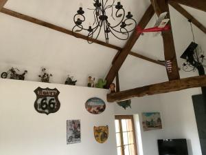 a room with a chandelier and signs on the wall at Gîte à la campagne in Saint-Léger-du-Gennetey