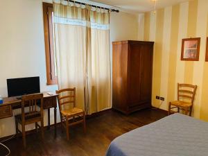 a bedroom with a desk with a computer and a bed at B&B Al Ponte in Padova