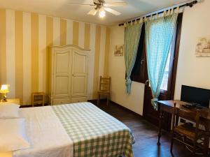 a bedroom with a bed and a desk and a television at B&B Al Ponte in Padova