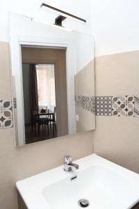 a bathroom with a white sink and a mirror at Suite Garibaldi in Cefalù +50 photos