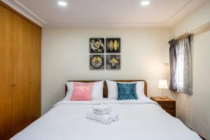 a bedroom with a large white bed with colorful pillows at AT NANA-5Bed, CITY CENTER, Nana BTS, MBK, Central World, Siam in Bangkok