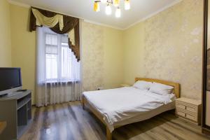 a bedroom with a bed and a tv and a window at Квартира подобово біля Площі Ринок вулиця Староєврейська 17 in Lviv