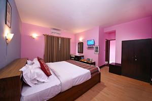 1 dormitorio con 1 cama grande y paredes de color rosa en Sacred Boutique Hotel, en Katmandú