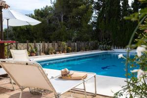 una piscina con una silla y una toalla. en Villa Geneviève Costa del Sol, en Mijas Costa
