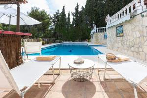 una piscina con due sedie e un tavolo di Villa Geneviève Costa del Sol a Mijas Costa