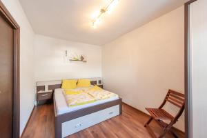 a small bedroom with a bed and a chair at Appartement 101 in Bichlbach