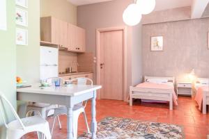 a kitchen with a table and a dining room at Dimitra's Garden - Holiday Apartments in Parga