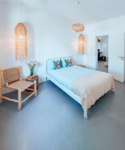 um quarto com uma cama azul e uma cadeira em Maison Comporta na Comporta