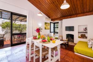 een woonkamer met een witte tafel met fruit erop bij Casas Barulho - Villa Jacaranda A8 in Albufeira