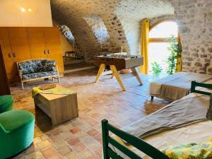 une chambre avec une table et un canapé dans l'établissement Mas Ardechois proche Vallon pont d'arc, à Villeuneuve-de-Berg