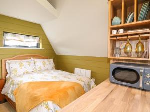 a bedroom with a bed and a microwave on a table at Buttercup Lodge in Doncaster