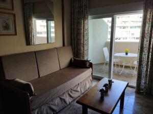a living room with a couch and a table at "VIVE BENAL BEACH" estudio 4314 con parque acuático in Benalmádena