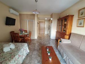 a living room with a couch and a table at "VIVE BENAL BEACH" estudio 4314 con parque acuático in Benalmádena