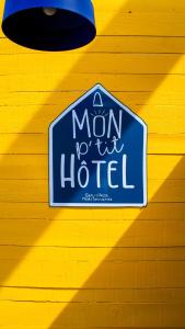 a sign for a mom hotel on a yellow wall at Mon P'tit Hôtel in Le Grau-dʼAgde