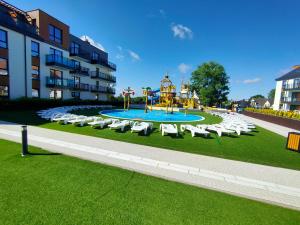 a playground with white chairs and a playground at Bel Mare Prestige by Four Seasons in Międzyzdroje