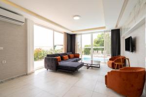un soggiorno con divano, sedie e una grande finestra di Ada Villas a Kusadası
