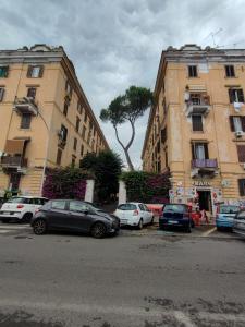 un gruppo di auto parcheggiate in un parcheggio accanto agli edifici di GAZ HOME RETRÒ Apartment a Roma
