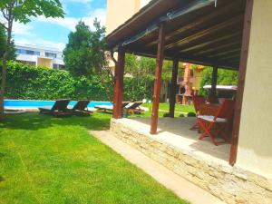 a pavilion with chairs and a pool in a yard at Vila Eclipse Mamaia nord in Mamaia Nord