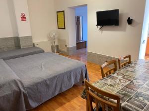 a room with two beds and a table and a tv at Giorno&Notte Colleferro in Colleferro