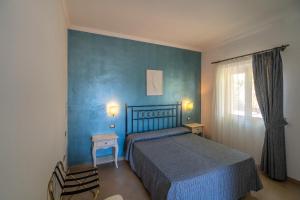 a bedroom with a bed and a blue wall at Hotel Boutique Il Castellino Relais in Vieste