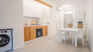 cocina y comedor con mesa y lavadora en Elide Home Sweet Home - Italian Homing, en Padenghe sul Garda