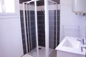 y baño con ducha de cristal y lavabo. en Le Marais - Village Vacances, en Meschers-sur-Gironde