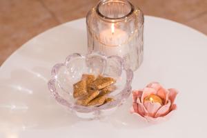 a candle and a glass bowl with a flower on a table at SOFI'S house in Rhodes Town