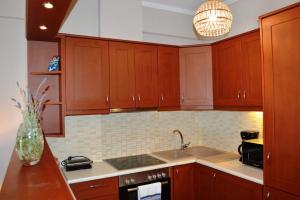 una cocina con armarios de madera y fregadero en Best House, Sea View II, Pylos Messinias en Pylos