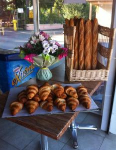 einen Tisch mit einem Haufen Croissants und einem Korb Brot in der Unterkunft Mobil-Home 6 Places (3 chambres) tout équipé in Soulac-sur-Mer