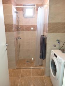 a bathroom with a shower and a washing machine at Itaka - Belgrade City Center in Belgrade