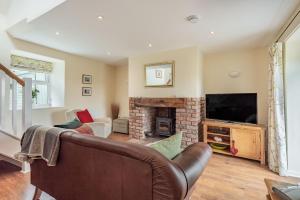 a living room with a couch and a fireplace at Hafan Haydn in Cwm