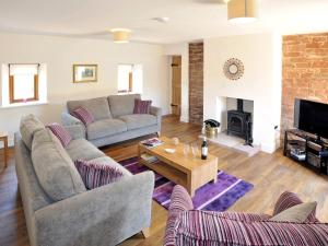 a living room with two couches and a table at The Old Grainstore in Wigton