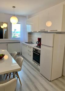 a kitchen with a white refrigerator and a table at Citadel Residence in Alba Iulia