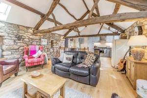 a living room with a leather couch and a table at Berts Cottage in Great Ormside