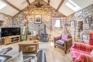 sala de estar con pared de piedra en Berts Cottage, en Great Ormside