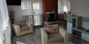 ein Wohnzimmer mit 2 Stühlen und einem TV in der Unterkunft Апартамент При Рени in Kopriwschtiza