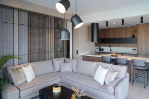 een woonkamer met een bank en een keuken bij AGAVE HILL LUXURY HOUSE in Chania